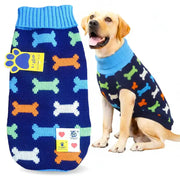 A dog sweater shown both flat and modeled by a yellow Labrador Retriever. The sweater is navy blue with a light blue ribbed collar and cuffs, decorated with colorful patterned bone motifs in orange, light green, and white.