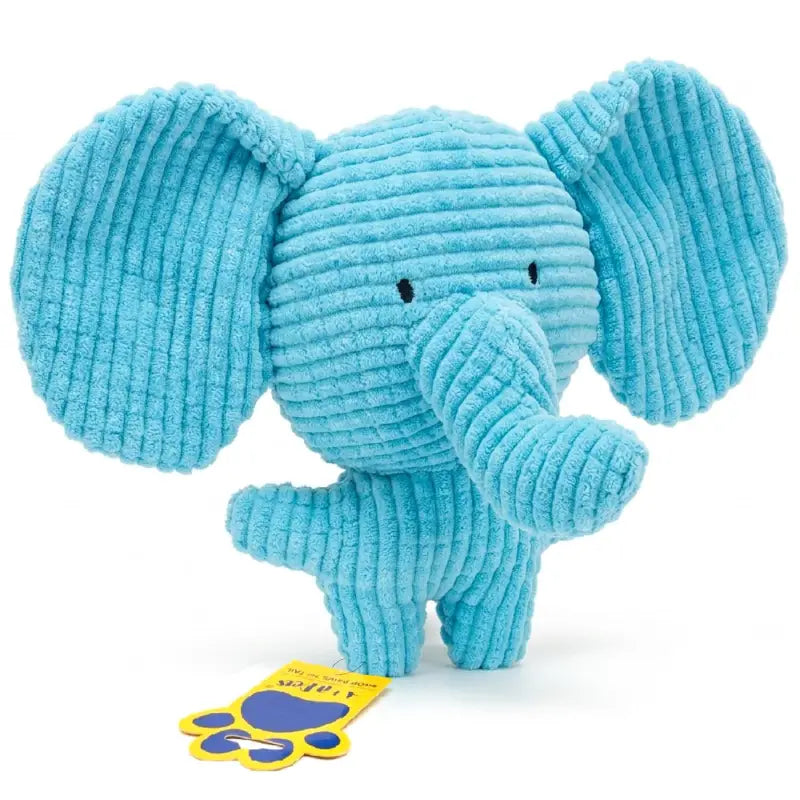 A light blue ribbed corduroy elephant plush toy with small black embroidered eyes, standing on a white background with a yellow and blue tag attached near its feet.