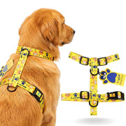Dog wearing a yellow harness with cartoon designs on a white background
