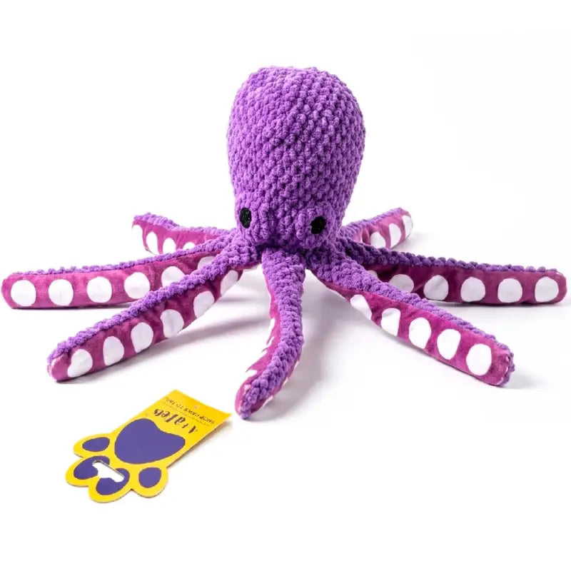 A purple knitted octopus dog toy with pink and white polka-dotted tentacles, shown on a white background with its yellow and purple tag.