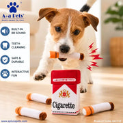 A small white and tan dog is chewing a novelty toy cigarette-shaped treat stick, with several similar toy sticks on a wooden floor. A red and white pack-shaped toy and product feature callouts are also shown.