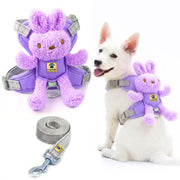 Purple plush dog harness with a bunny-shaped attachment and a gray leash, shown both alone and worn by a white dog on a white background.
