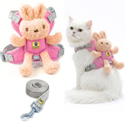Pink pet harness set with a plush bunny attachment and gray leash, shown both as a standalone product and worn by a white cat on a white background.