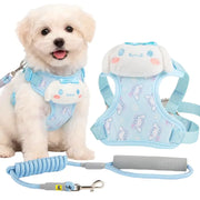 A small white puppy wearing a light blue dog harness with a plush character face, shown next to the harness laid flat and a matching blue leash on a white background.