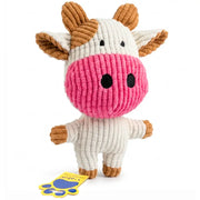 A plush cow dog toy made of ribbed corduroy fabric, featuring a cream-colored body, a bright pink snout, and brown horns and hooves, standing on a white background with a yellow tag.
